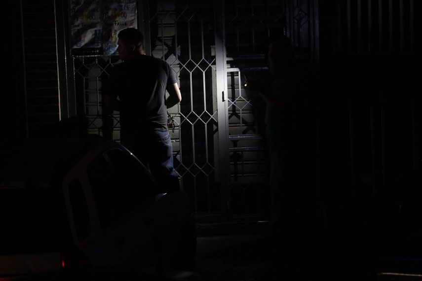 Un hombre cierra una puerta en la oscuridad por la falta de fluido eléctrico en Caracas, Venezuela.&nbsp;