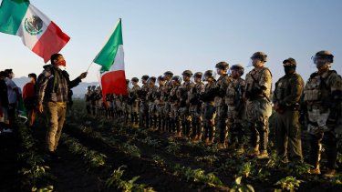 Soldados de la Guardia Nacional bloquean a los manifestantes que ondean bandera de México durante una redada de inmigración de ICE en una granja de cannabis cercana el 10 de julio de 2025 cerca de Camarillo, California.