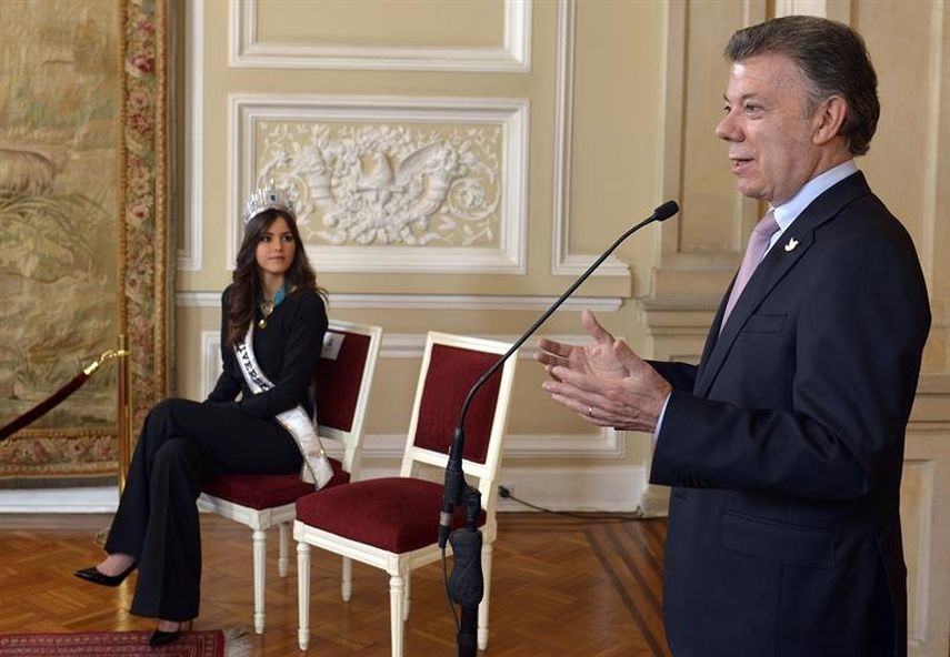 Miss Universo Paulina Vega escucha al presidente de Colombia Juan Manuel Santos. (EFE)