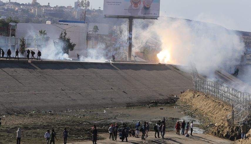 La policía fronteriza utiliza gases lacrimógenos para evitar que grupos de personas crucen la garita El Chaparral, de la ciudad de&nbsp;Tijuana,
