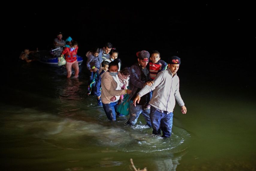 Migrantes, la mayoría centroamericanos, caminan por un río al llegar a la frontera en Roma, Texas.