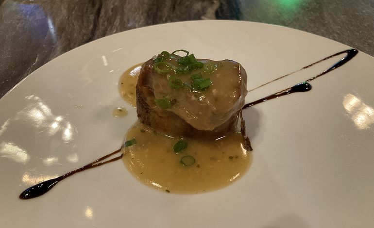 Solomillo de cerdo al pil pil de ajo y perejil sobre patata a la parrilla.