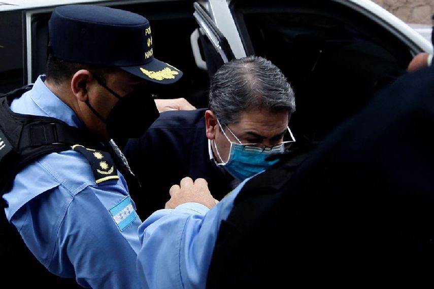 Policías escoltan al expresidente Juan Orlando Hernández a su llegada al Palacio de Justicia para asistir a su primera audiencia de extradición en Tegucigalpa, el 16 de febrero de 2022.