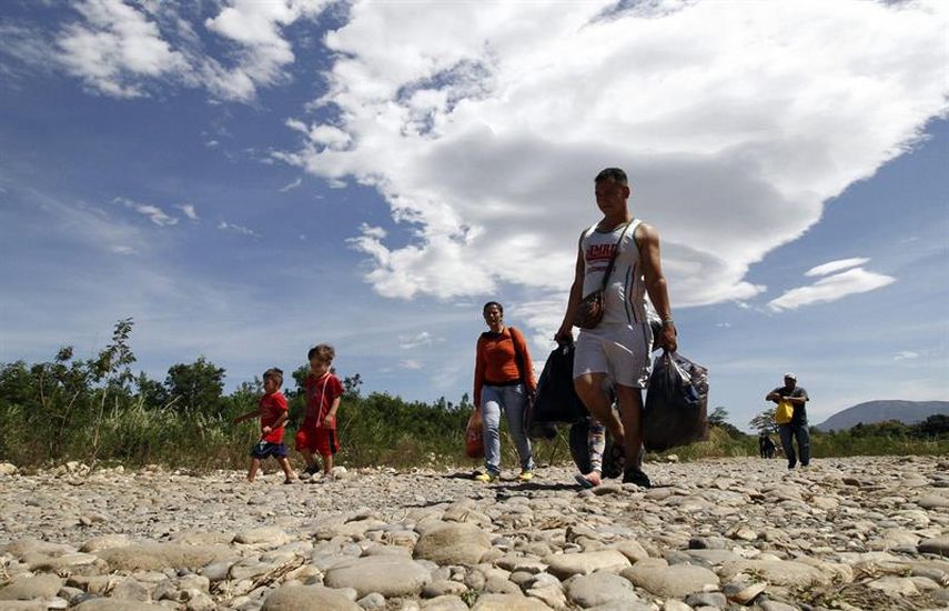  Familias colombianas cruzan desde Venezuela hacia Colombia a través del rio Táchira. (EFE)