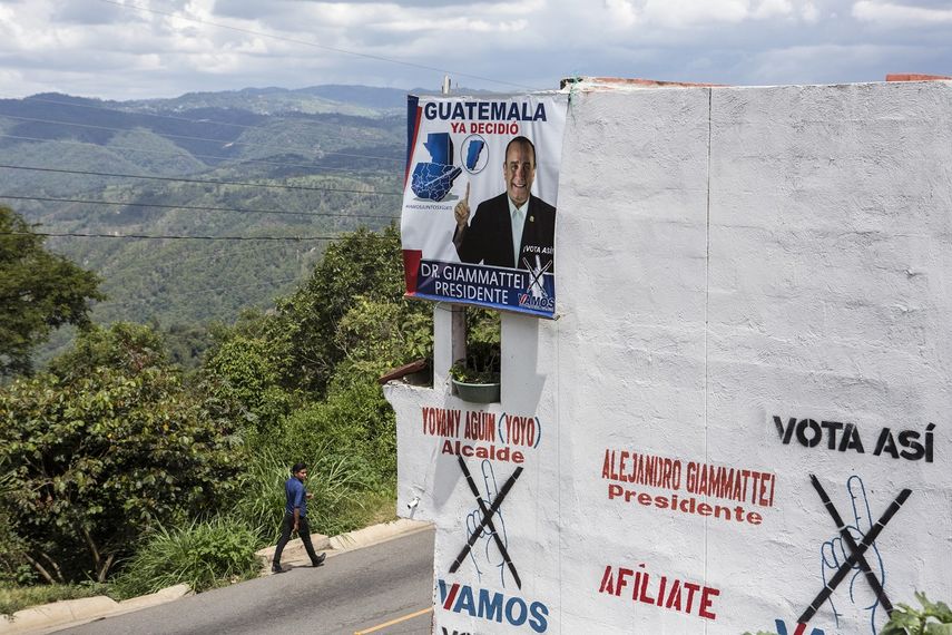 Un hombre camina frente a una casa&nbsp;con propaganda pol&iacute;tica del candidato presidencial Alejandro Giammattei del partido Vamos, en San Mart&iacute;n Jilotepeque, el domingo 4 de agosto de 2019.&nbsp;