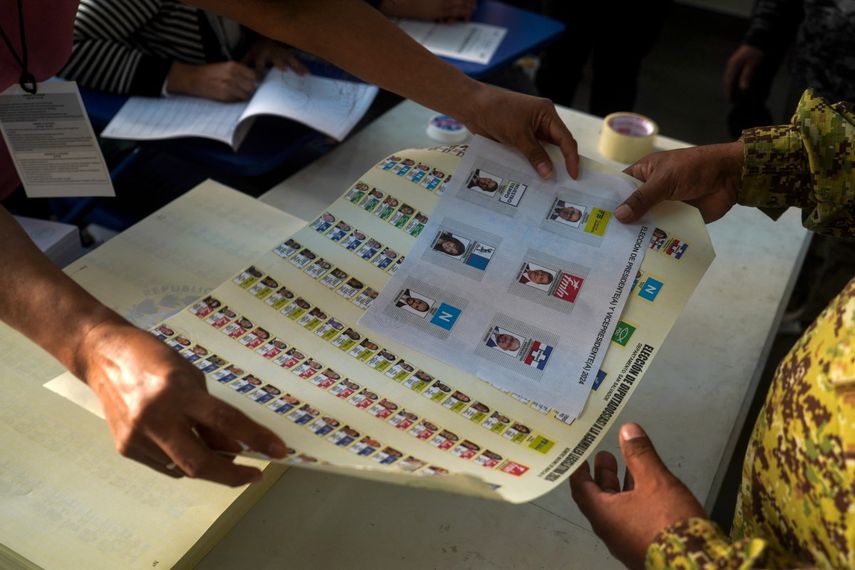 Un soldado recibe una boleta de votación durante las elecciones presidenciales y legislativas en un colegio electoral del barrio Campanera en Soyapango, El Salvador, el 4 de febrero de 2024.