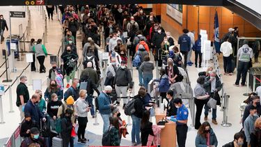 Pasajeros llevan mascarillas mientras esperan en una fila para un control de seguridad de la Administración de Seguridad del Transporte (TSA), el 10 de diciembre de 2021, en el Aeropuerto Internacional de Seattle-Tacoma en Seattle.&nbsp;