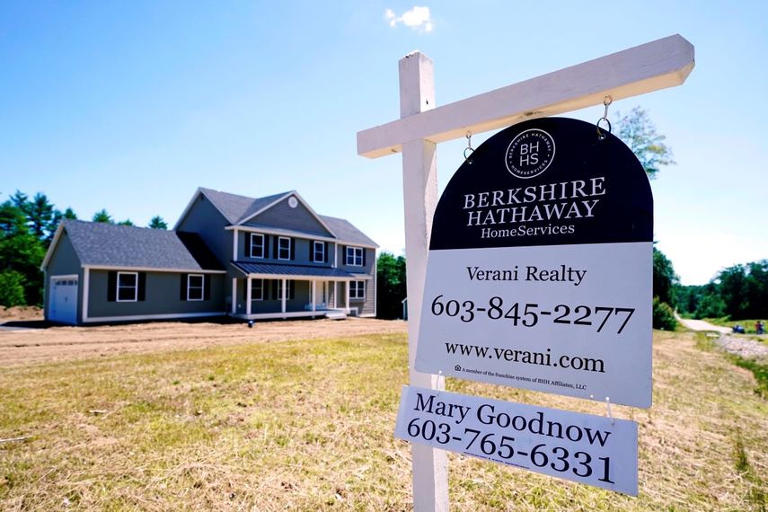 Un cartel de inmobiliaria frente a una casa unifamiliar nueva en venta en Auburn, Nuevo Hampshire.