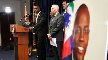 Una imagen del presidente haitiano Jovenel Moïse, a la derecha, es expuesta mientras Markenzy Lapointe, fiscal federal para el Distrito Sur de Florida, a la izquierda, habla durante una conferencia de prensa tras el arresto de cuatro presuntos implicados en el asesinato de Moïse, el 14 de febrero de 2023, en Miami.