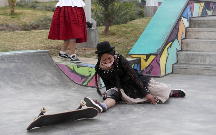 Ayde Choque, con una m&aacute;scara en medio de la pandemia de COVID-19 y vestida como una chola, monta una patineta durante un show de talentos juveniles en La Paz, Bolivia, el mi&eacute;rcoles 30 de septiembre de 2020.&nbsp;