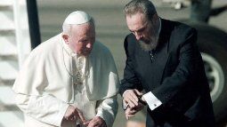 El dictador cubano Fidel Castro (izquierda) mira su reloj mientras él y el Papa Juan Pablo II (derecha) caminan por la pista del aeropuerto internacional José Martí en La Habana el 21 de enero de 1998, momentos después de que el Papa llegara para una gira por la isla.&nbsp;