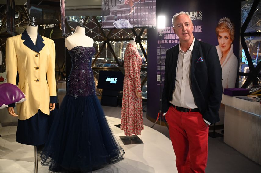 La foto tomada el 17 de abril de 2024 muestra a Martin Nolan, cofundador y director ejecutivo de Juliens Auctions, de pie junto a los vestidos que alguna vez usó la princesa Diana en una vista previa para los medios antes de la subasta titulada “La elegancia de la princesa Diana y una colección real”.