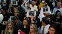 Personas sosteniendo una imagen del difunto fiscal antidrogas Marcelo Pecci asisten a una reunión para exigir justicia por su asesinato, en Asunción, Paraguay, el viernes 13 de mayo de 2022. 