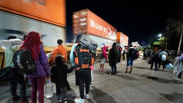 Migrantes miran un tren de mercancías mientras esperan a un tren rumbo al norte que se detenga el tiempo suficiente para subir a él, en Irapuato, México, el sábado 23 de septiembre de 2023.