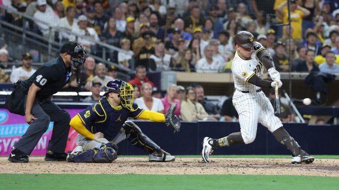 Freddy Fermín #54 de los Padres de San Diego conecta un sencillo productor de oro durante la undécima entrada de un juego, mientras William Contreras #24 de los Cerveceros de Milwaukee observa en el Petco Park el 22 de septiembre de 2025 en San Diego, California. Los Padres de San Diego derrotaron a los Cerveceros de Milwaukee 5-4 para avanzar a los playoffs de la MLB.&nbsp;