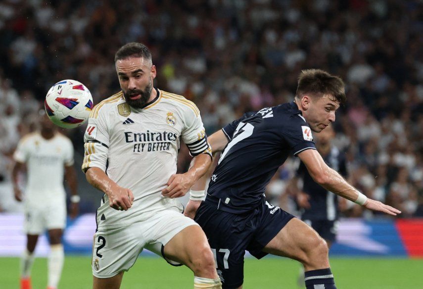 El defensor español del Real Madrid # 02 Dani Carvajal compite con el defensor escocés de la Real Sociedad # 17 Kieran Tierney durante el partido de fútbol de la Liga española entre el Real Madrid y la Real Sociedad en el estadio Santiago Bernabeu de Madrid el 17 de septiembre de 2023.  