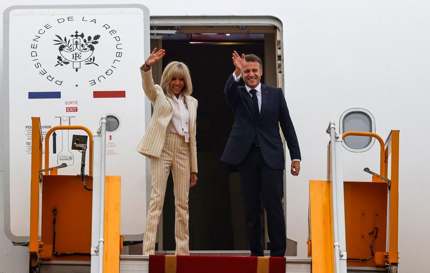 El presidente de Francia, Emmanuel Macron, y su esposa, Brigitte Macron, saludan al abordar su avión para partir tras su visita a Vietnam en el Aeropuerto Internacional Noi Bai de Hanói el 27 de mayo de 2025.