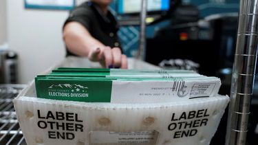 Una empleada del correo colecta boletas de votación.