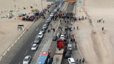 Camiones y autos están atascados mientras migrantes venezolanos bloquean la entrada a Chile en la frontera peruana con Chile, en Tacna, Perú. Una crisis migratoria en la frontera entre Chile y Perú se intensificó mientras cientos de migrantes permanecían varados al no poder cruzar a Perú.