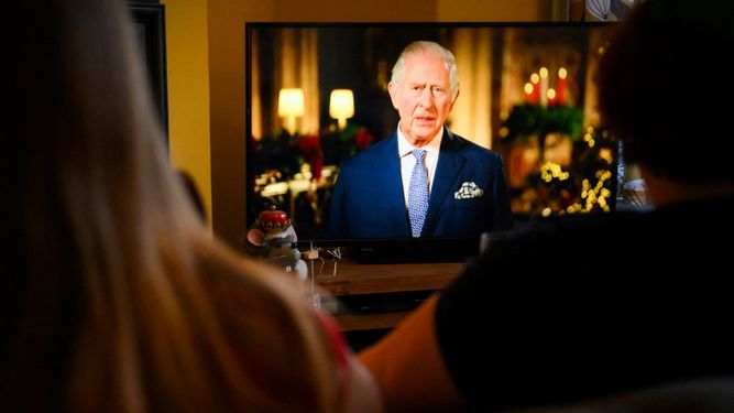 Una familia sentada en una sala de estar en Liverpool ven al rey Carlos III en su primer mensaje anual del día de Navidad, en la televisión, el 25 de diciembre de 2022.&nbsp;