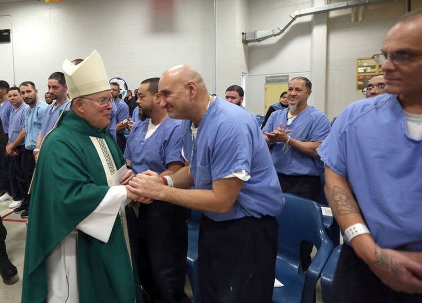 Arzobispo Charles J. Chaput saluda a los reclusos en la Misa en el Fondo para el Curran Fromhold Correccional en el noreste de Filadelfia, en enero de 2015. (FACEBOOK)