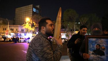 Un manifestante besa una réplica de un casquillo de bala mientras otros se reúnen en la Plaza Palestina en Teherán el 14 de abril de 2024, después de que Irán lanzara un ataque con aviones no tripulados y misiles contra Israel.