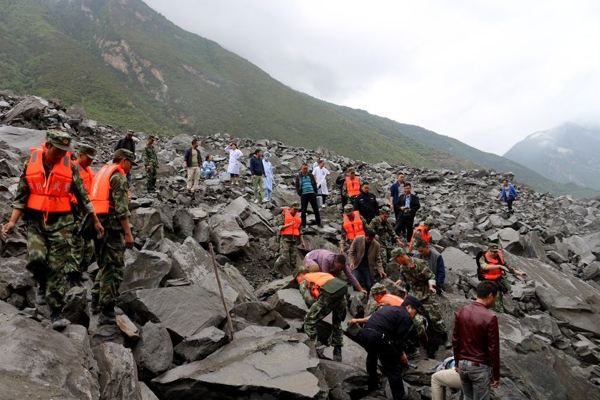 Los equipos de rescate trabajan en el sitio de un derrumbe masivo donde se estima que más de 120 aldeanos están enterrados, en el condado de Maoxian, en la provincia de Sichuan, en el suroeste de China.