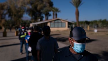 Jornaleros agrícolas hispanos hacen fila para recibir la vacuna de Pfizer-BioNTech contra el COVID-19 el jueves 21 de enero de 2021, en Mecca, California.