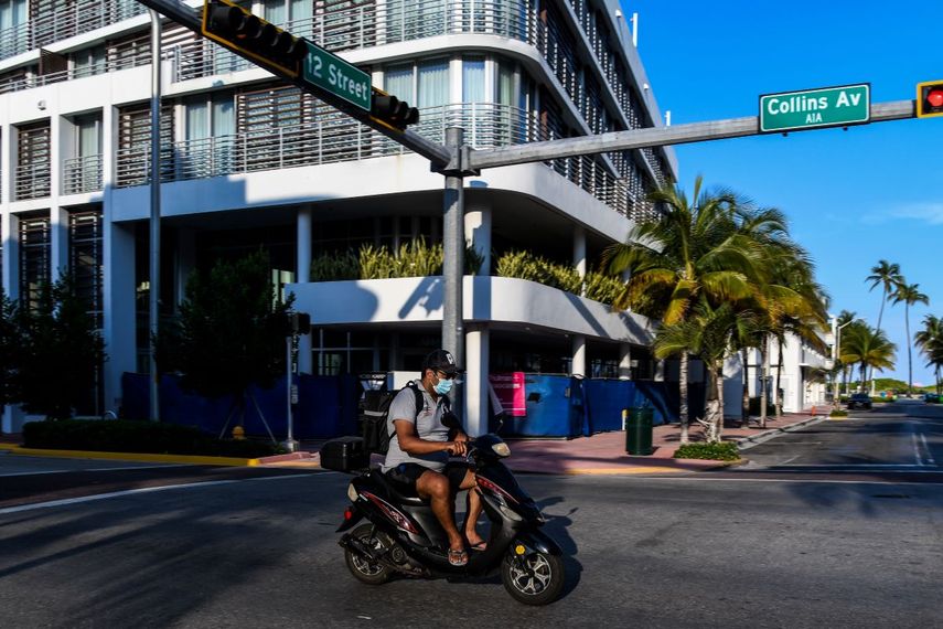 Un hombre usa una máscarilla mientras circula en su motocicleta por Ocean Drive en South Beach, en Miami, en medio de temores sobre la propagación del nuevo coronavirus (COVID-19), el 31 de marzo de 2020. 