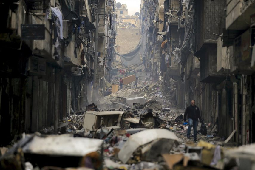 Gente camina sobre los escombros del barrio de Salaheddine, antes en poder de rebeldes, en Alepo, Siria, 20 de enero de 2017. La ONU dijo en un informe difundido el martes 28 de junio de 2022 que los primeros 10 años de la guerra en Siria, que comenzó en 2011, dejó más de 300.000 civiles muertos.&nbsp;