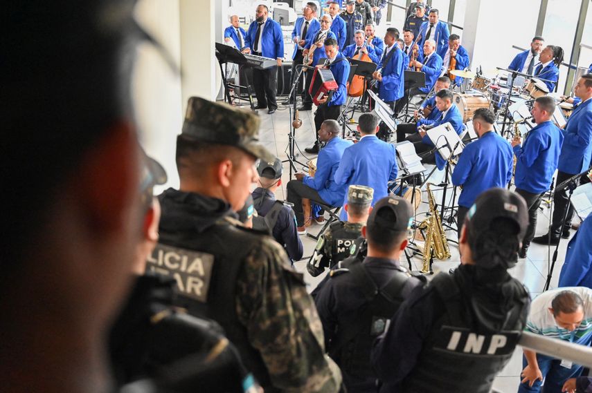 Miembros de la orquesta Libertad se presentan durante un concierto por el Día de las Madres, custodiados por guardias penitenciarios y agentes de la Policía Militar de Orden Público (PMOP), en la sede del Instituto Nacional Penitenciario (INP) en Tegucigalpa, el 9 de mayo de 2025.