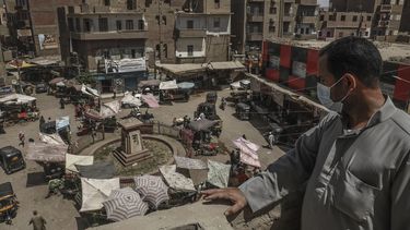 Ashraf Sayed, residente de la población de Monshah, donde hay un auge del coronavirus, contempla un mercado desde lo alto de un edificio en Sohag, Egipto, 2 de mayo de 2021. 