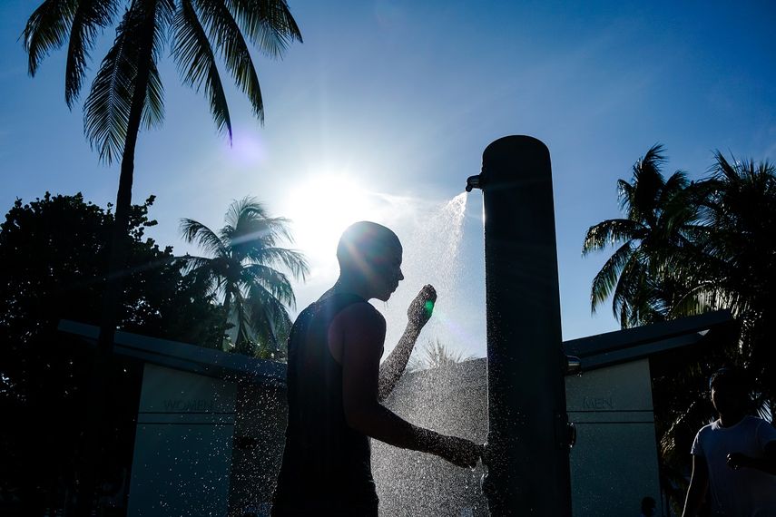 Un hombre se enjuaga en la playa de Miami Beach, Florida, el 27 de agosto de 2020, en medio de la pandemia de coronavirus.