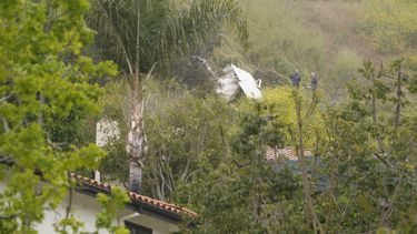 Investigadores de la Junta Nacional de Seguridad en el Transporte inspeccionan una avioneta que cayó sobre una colina, cerca de una casa, en Beverly Glen Circle, el domingo 30 de abril de 2023, en Los Ángeles.&nbsp;
