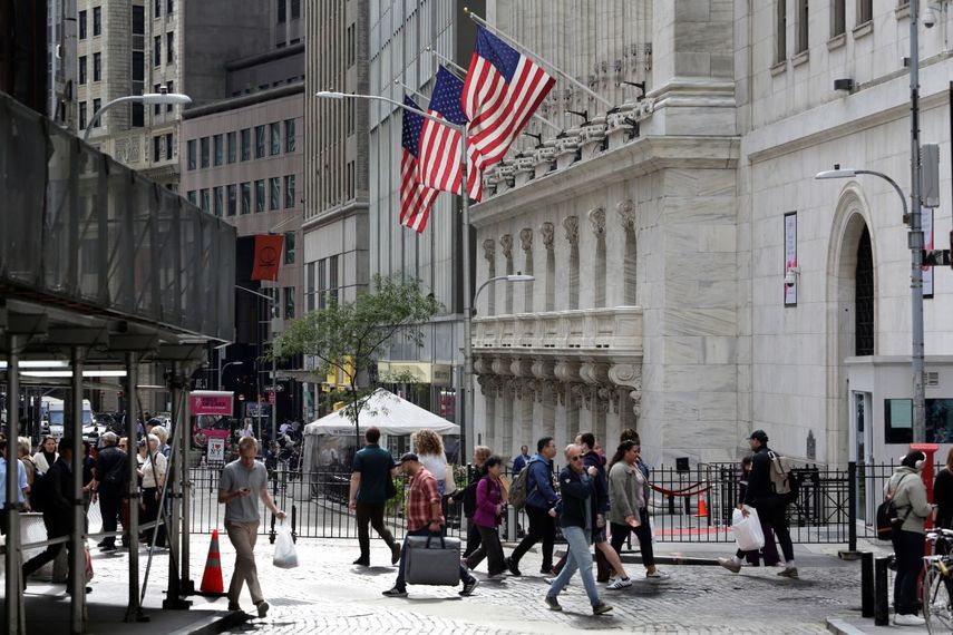 Personas caminan frente a la Bolsa de Valores, en Nueva York.