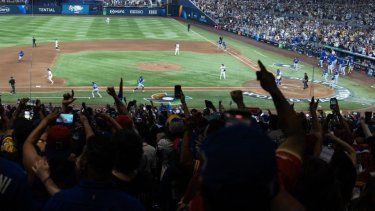 Los aficionados reaccionan cuando Jackson Chourio #1 del equipo de Venezuela anota una carrera gracias a un sencillo productor de su compañero Maikel García #11 contra el equipo de Italia en la séptima entrada en el loanDepot Park el 16 de marzo de 2026 en Miami, Florida.&nbsp;