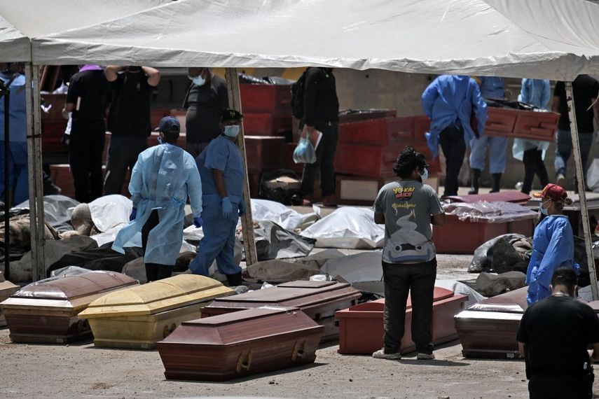 Peritos forenses se encuentran entre las víctimas y los ataúdes en La Guaira, estado de La Guaira, Venezuela, el 29 de junio de 2026, tras los dos terremotos gemelos ocurridos el 24 de junio.