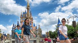 Varias personas caminan dentro de uno de los emblemáticos parques de Disney Magic Kingdom. Varias personas caminan dentro de uno de los emblemáticos parques de Disney Magic Kingdom.