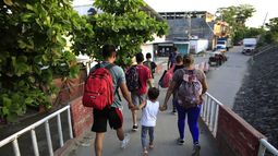 Migrantes, algunos de ellos salvadoreños, caminan hacia una localidad después de llegar desde Guatemala cruzando en balsa el Río Suchiate, hacia Ciudad Hidalgo, México, en junio de 2019.&nbsp;