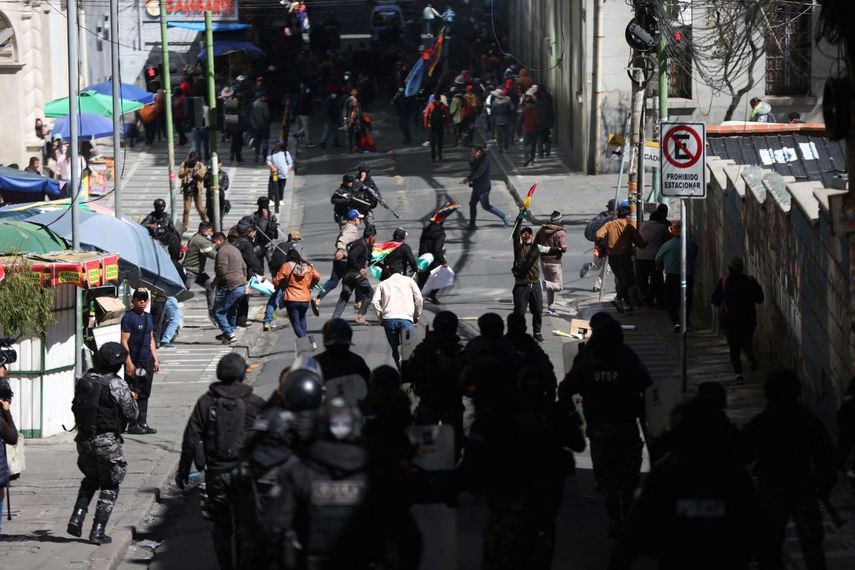 Simpatizantes del expresidente de Bolivia Evo Morales (2006-2019) corren durante un enfrentamiento con policías este miércoles, en La Paz, Bolivia.