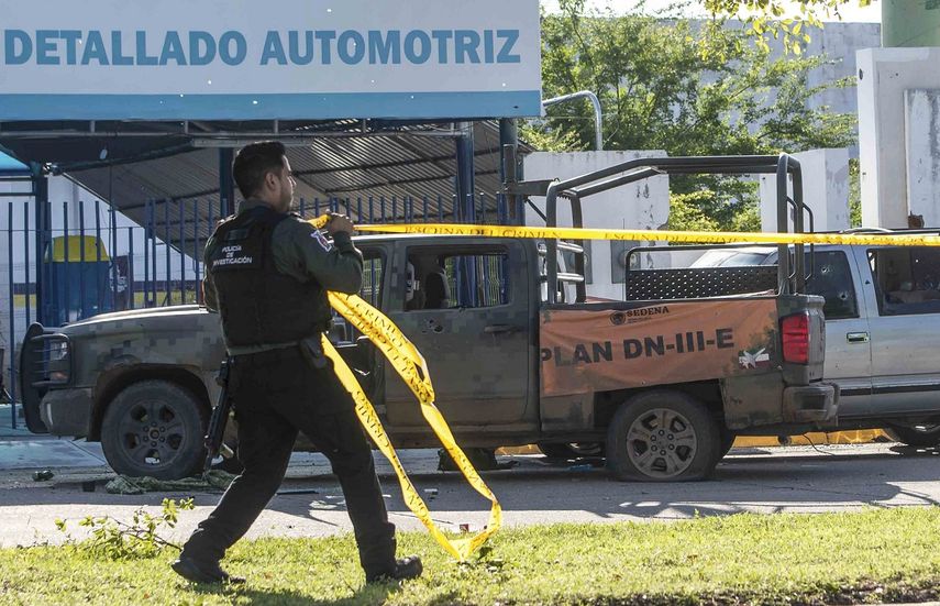 Un oficial de policía de México pone cinta amarilla para asegurar la escena del crimen.
