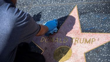 En esta foto de archivo, un trabajador de mantenimiento usa un producto de limpieza para eliminar el graffiti despu&eacute;s de que la estrella de Donald Trump en el Paseo de la Fama de Hollywood fue vandalizada, en un Hollywood, California, el 23 de abril de 2020, durante la pandemia del coronavirus COVID-19.