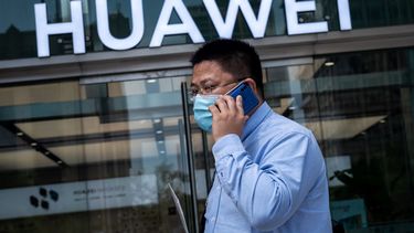 Una persona pasa frente a una tienda del fabricante de telecomunicaciones Huawei.