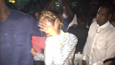 La cantante Beyoncé se cubre el rostro durante su visita junto a su marido Jay-Z, vestido de blanco, a una discoteca de República Dominicana. (TWITTER)
