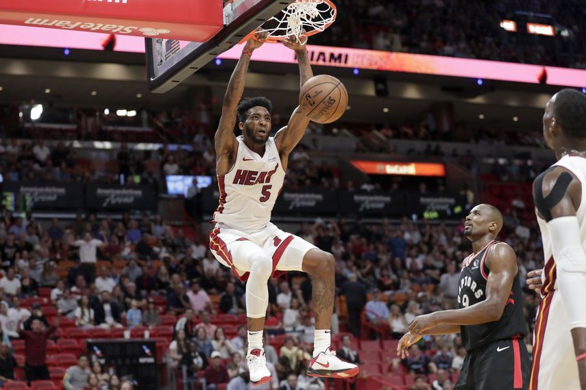 El alero del Heat de Miami Derrick Jones Jr. clava el balón ante la mirada del alero de los Raptors de Toronto Serge Ibaka en la segunda mitad del juego del jueves 2 de enero de 2020, en Miami. 
