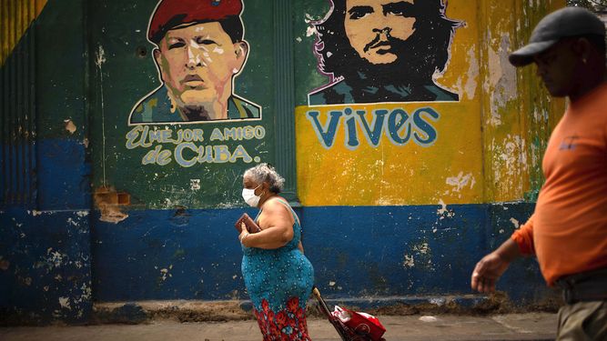 Una mujer&nbsp;con m&aacute;scarilla protectora&nbsp;contra el&nbsp;coronavirus tira de su carrito de compras mientras camina hacia el mercado en La Habana.&nbsp;