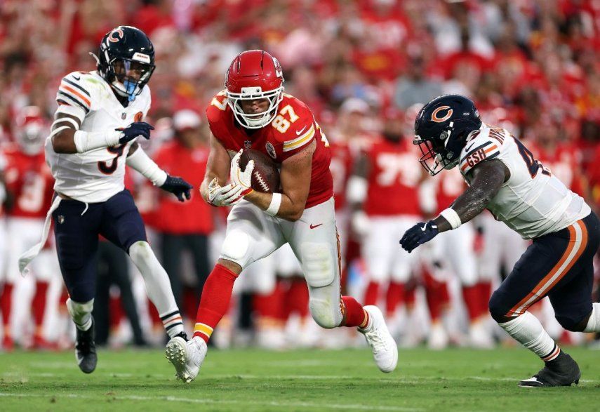 El ala cerrada Travis Kelce #87 de los Kansas City Chiefs lleva el balón tras realizar una recepción mientras el safety Jaquan Brisker #9 y el linebacker Ruben Hyppolite II #47 de los Chicago Bears defienden durante el primer cuarto del partido de pretemporada de la NFL 2025 en el Estadio Arrowhead el 22 de agosto de 2025 en Kansas City, Misuri.&nbsp;