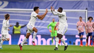El joven uruguayo Álvaro Rodríguez celebra con el defensor alemán Antonio Rudiger tras anotar el gol del empate para el Real Madrid contra el Atlético de Madrid