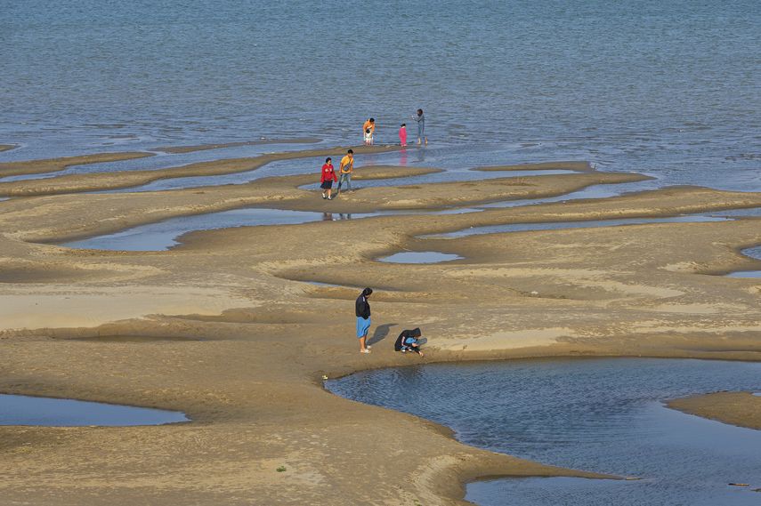 Curiosos caminan por los bancos de arena que han salido a la superficie por el descenso del nivel de las aguas en el r&iacute;o Mekong. Foto del 4 de diciembre del 2019 tomada en la provincia tailandesa de Nakhon Phanon.&nbsp;