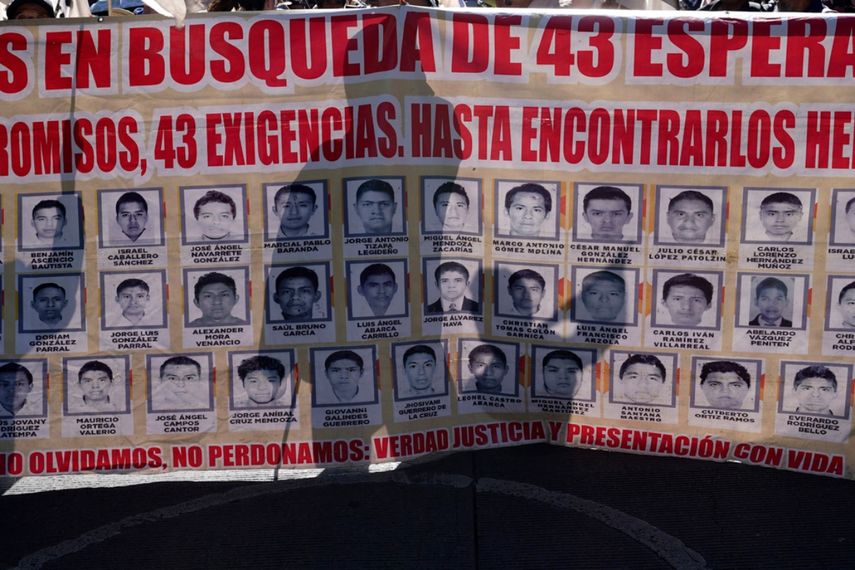 Familiares y simpatizantes de los 43 estudiantes de Ayotzinapa marchan con un gran cartel que muestra sus fotografías y nombres por el noveno aniversario de su desaparición, en Ciudad de México.